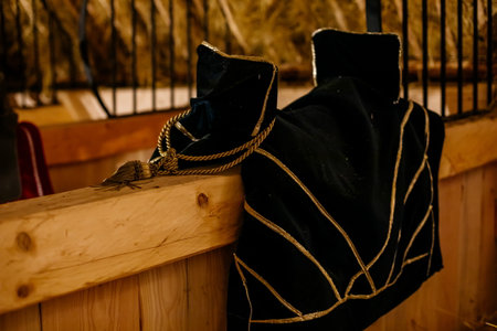 Krivoklat, Czech Republic, 21 August 2022: fortified medieval royal castle, National cultural landmark, interior of stable with stalls for horses, hay and leather saddles on wooden partitionsのeditorial素材