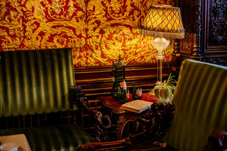 Hradek u nechanic, Czech Republic, 8 October 2022: Castle or chateau interior with wooden carved furniture, guest room with leather gilded Belgian wallpaper, glass vintage decanterのeditorial素材