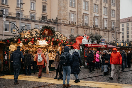 Dresden, Saxony, Germany, 10 December 2022: Christmas outdoor market stall decorations with fairy c lights, vibrant signs banners, coniferous spruce green branches, Striezelmarkt on Altmarkt squareのeditorial素材