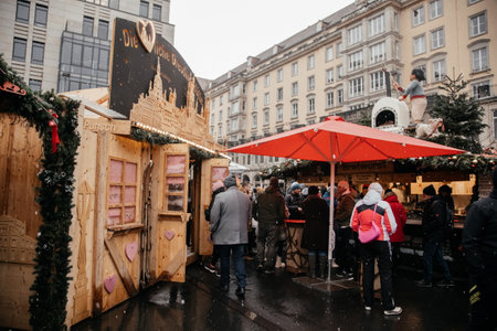 Dresden, Saxony, Germany, 10 December 2022: Christmas outdoor market stall decorations with fairy c lights, vibrant signs banners, coniferous spruce green branches, Striezelmarkt on Altmarkt squareのeditorial素材