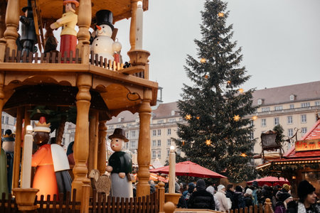 Dresden, Saxony, Germany, 10 December 2022: Christmas outdoor market stall decorations with fairy with lights, Rotating wooden pyramid, nutcrackers as symbol of holiday, winter day and snow, candlesのeditorial素材