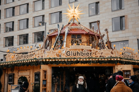 Dresden, Saxony, Germany, 10 December 2022: Christmas outdoor market stall decorations with fairy c lights, vibrant signs banners, coniferous spruce green branches, Striezelmarkt on Altmarkt squareのeditorial素材