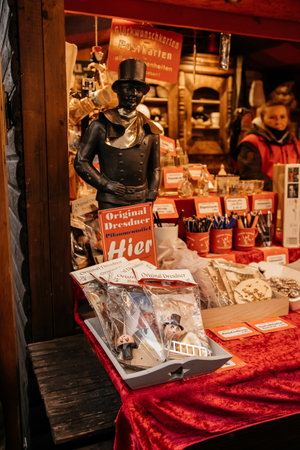 Dresden, Saxony, Germany, 10 December 2022: Christmas outdoor market stall decorations with fairy with lights, pflaumentoffel haus, plum fool man character, sell food, winter day and snowのeditorial素材