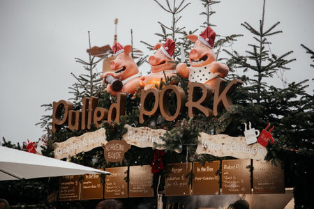 Dresden, Saxony, Germany, 10 December 2022: Christmas outdoor market stall decorations with fairy c lights, vibrant signs banners, coniferous spruce green branches, Striezelmarkt on Altmarkt squareのeditorial素材