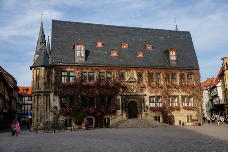 Quedlinburg, Saxony-Anhalt, Germany, 28 October 2022: Historic gothic townhall or Rathaus with Roland statue in Market Square, vintage colored timber frame houses in medieval town at sunny autumn dayのeditorial素材
