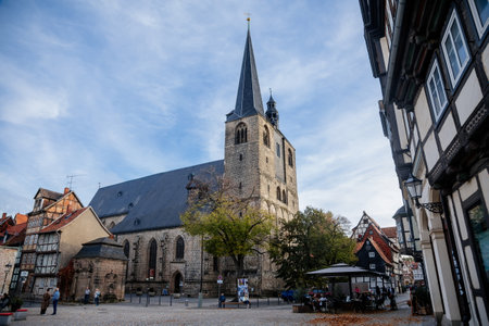 Quedlinburg, Germany, 28 October 2022: Romanesque and Gothic Market Church St. Benedikti in the center of historic Old Town at sunny autumn day, vintage timber frame housesのeditorial素材