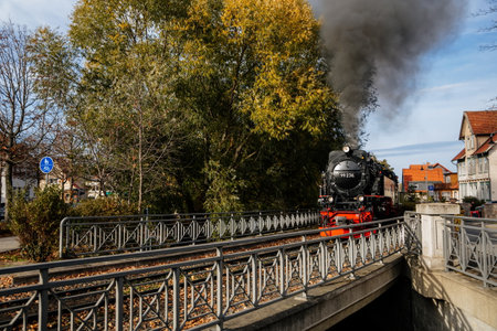 Wernigerode, Germany, 29 October 2022: Steam engine train in Harz Mountains Region, Old retro vintage steam locomotive near railway station at sunny day, white smoke from train chimney, Brocken Lineのeditorial素材