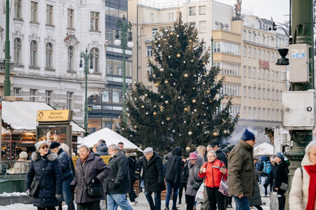 Prague, Czech Republic, 19 December 2022: Christmas market under snow with wooden stalls and luminous garlands in Republic Square in old town on sunny winter day, Christmas tree, New Year atmosphereのeditorial素材