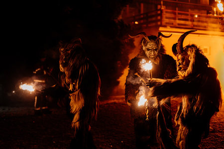 Trutnov, Czech Republic, 17 December 2022: Traditional show Zazij Krampus, parade of masks demonic creatures, devil in flames at winter night, Christmas holidays, fantasy handmade wooden masksのeditorial素材
