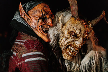 Trutnov, Czech Republic, 17 December 2022: Traditional show Zazij Krampus, parade of masks demonic creatures, devil in flames at winter night, Christmas holidays, fantasy handmade wooden masksのeditorial素材
