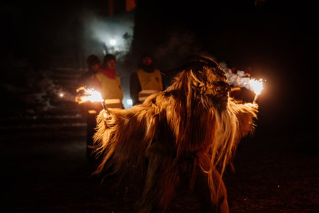 Trutnov, Czech Republic, 17 December 2022: Traditional show Zazij Krampus, parade of masks demonic creatures, devil in flames at winter night, Christmas holidays, fantasy handmade wooden masksのeditorial素材
