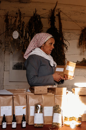 Kourim, Bohemia, Czech Republic, 17 December 2023: herbalist woman, bundles of dried flowers, packages of natural tea, Interior of Traditional rural house, open air ethnographic museumのeditorial素材