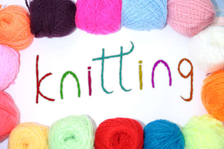 Colorful balls of yarn around the word knitting, made of wool yarn on a backgroundの写真素材