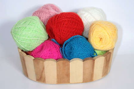 Colorful balls of wool yarn in a decorative basketの写真素材