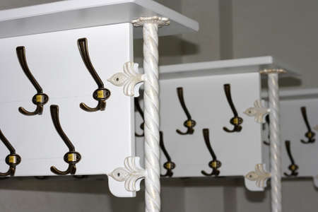 Metal dressing hooks with numbers on a white coat rack in the wardrobeの写真素材