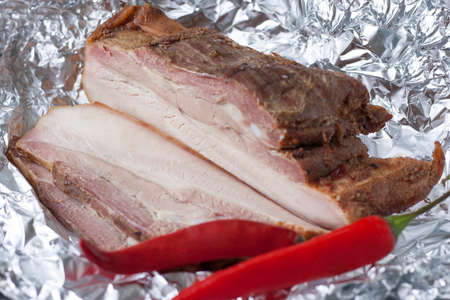 Pork baked in foil from the peritoneum with layers of fat with spicy red pepper. Traditional Ukrainian meat snack - podcherchevokの写真素材