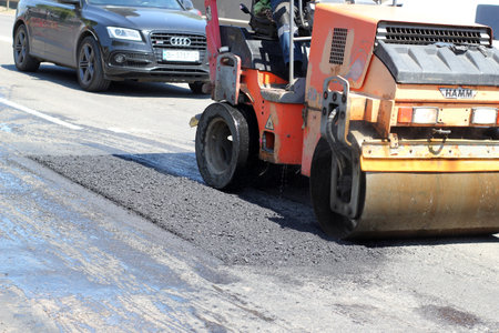Ukraine, Odessa, summer 2021. The rollers machine is repairing the road. Repair, complicated transport movementのeditorial素材