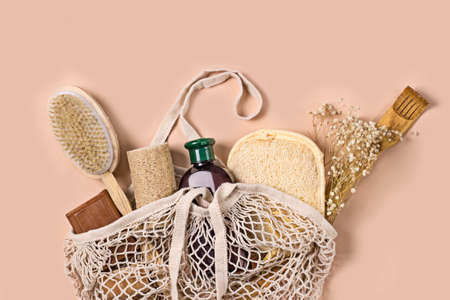 Cosmetic eco lotion and red fruits in eco bag on beige background. Sustainable lifestyle. Eco-friendly concept. Top viewの写真素材