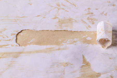 Horizontal background with a torn hole in torn coffee-colored paper. Curled up torn aged paper on coffee background. Breakthrough paper. Layout template.の写真素材