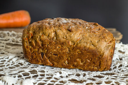 Loaf of healthy carrot bread on knitted retro napkin.