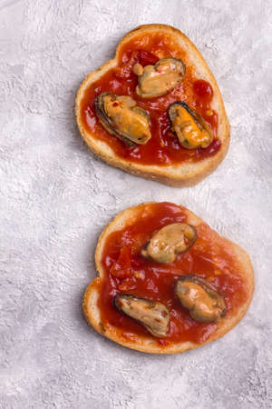 Open sandwich with mussels in tomato sauce. Homemade sandwich with toaster on a light background, top view. Delicious sandwiches with seafood.の写真素材