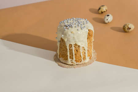 Three quail eggs and traditional cake with exquisite taste on a trendy isometric beige background with a shadow on the wall. The minimalism of an Easter card. Creative postcardの写真素材