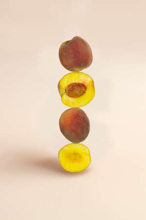 Half and whole peach fruit balancing on the table.の写真素材