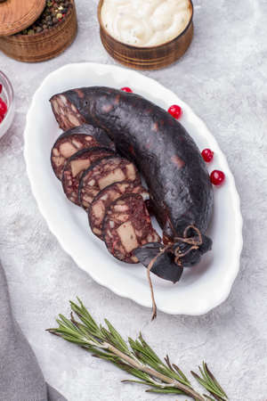 Traditional blood sausage on a white plate with cranberries.の写真素材