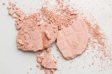 Face powder. Broken pieces of cosmetic powder on light background. Cosmetic smear. Make up a crushed powder.の写真素材