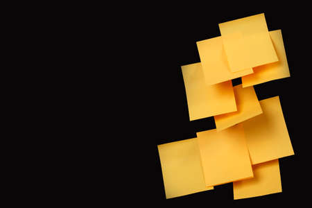 sticky note. Set of yellow folded note paper sheets, ready for your message on black background with copy spaceの写真素材