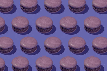 Flat lay of macaroons on violet background,a pattern of colorful french cookies macarons on trendy Very Peri. Color of the year 2022.の写真素材