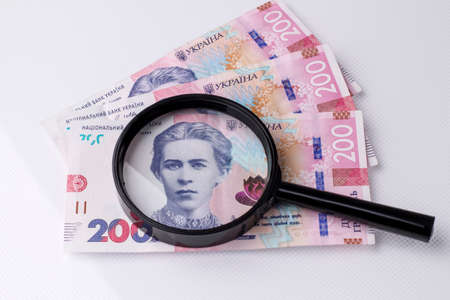 The national currency of Ukraine is the hryvnia. Magnifying glass on the Ukrainian banknote of 200 hryvnia. Ukrainian money.の写真素材