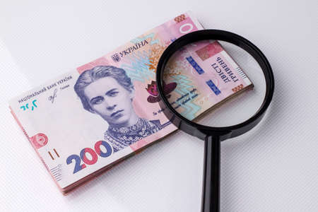 The national currency of Ukraine is the hryvnia. Magnifying glass on the Ukrainian banknote of 200...