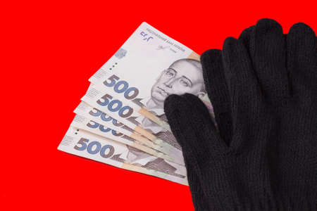 The national currency of Ukraine is the hryvnia. Black gloves on Ukrainian 500 hryvnia banknotes. Ukrainian money.の写真素材