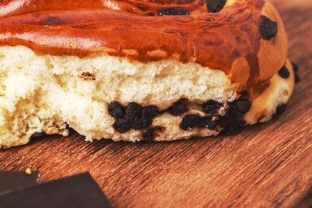 Broken freshly baked bun with chocolate pieces.