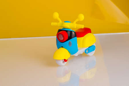 Yellow and blue plastic scooter motorcycle on light background with copy space.の写真素材