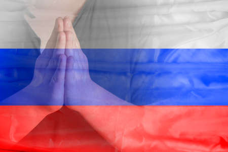 Man's hands folded in prayer. Pray for Russia. Relations between Russia and Ukraine.の写真素材