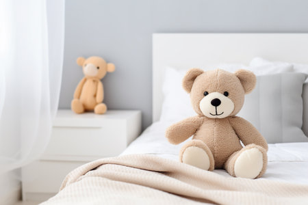 Cute teddy bear sitting on bed at home, space for textの素材