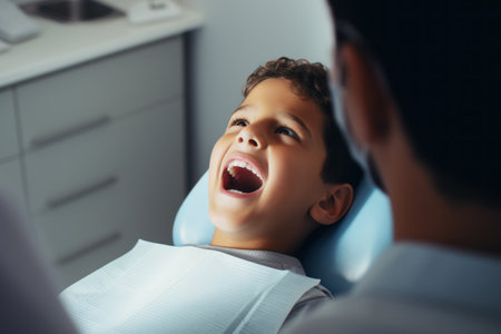 A young boy laughing joyfully while sitting in a dental chair during an examinationの素材