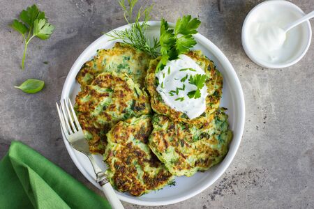 zucchini fritters, vegetarian zucchini pancakes, served with fresh herbs and garlic yogurt sauce, top viewの写真素材