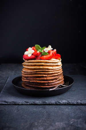 Ombre chocolate pancakes with fresh strawberry on dark background, selective focusの写真素材