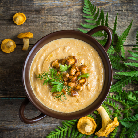 chanterelle mushroom cream soup on wooden background, top view, square imageの写真素材