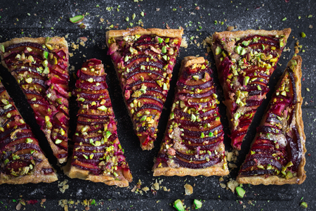 plum and pistachios tart on dark background , top viewの写真素材