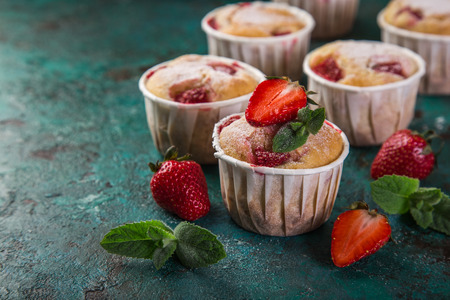 strawberry cupcakes with fresh berries on wooden tray, green background, selective focusの写真素材