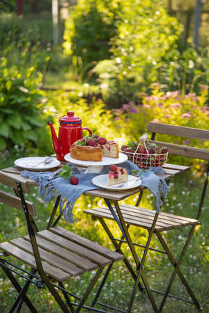 Table setting with summer strawberry cake in a garden, outdoor, selective focusの写真素材