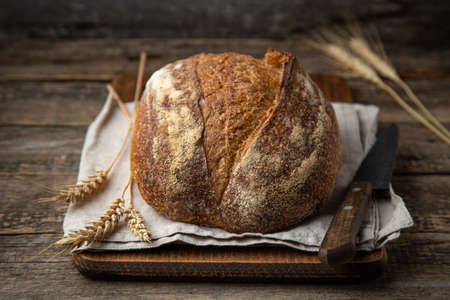 freshly baked homemade sour dough bread, wooden background