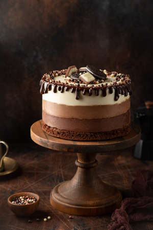 Three Chocolate mousse cake on cake stand, wooden background, selective focusの写真素材