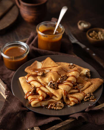 crepes with salted caramel and nuts, selective focus, wooden backgroundの写真素材