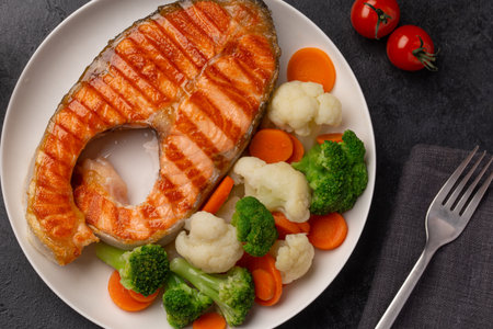 grilled salmon and vegetables, healthy eating and cooking food concept, dark background, top viewの写真素材