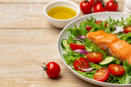 roasted salmon with vegetable salad, healthy eating and cooking food concept, wooden background, copy spaceの写真素材